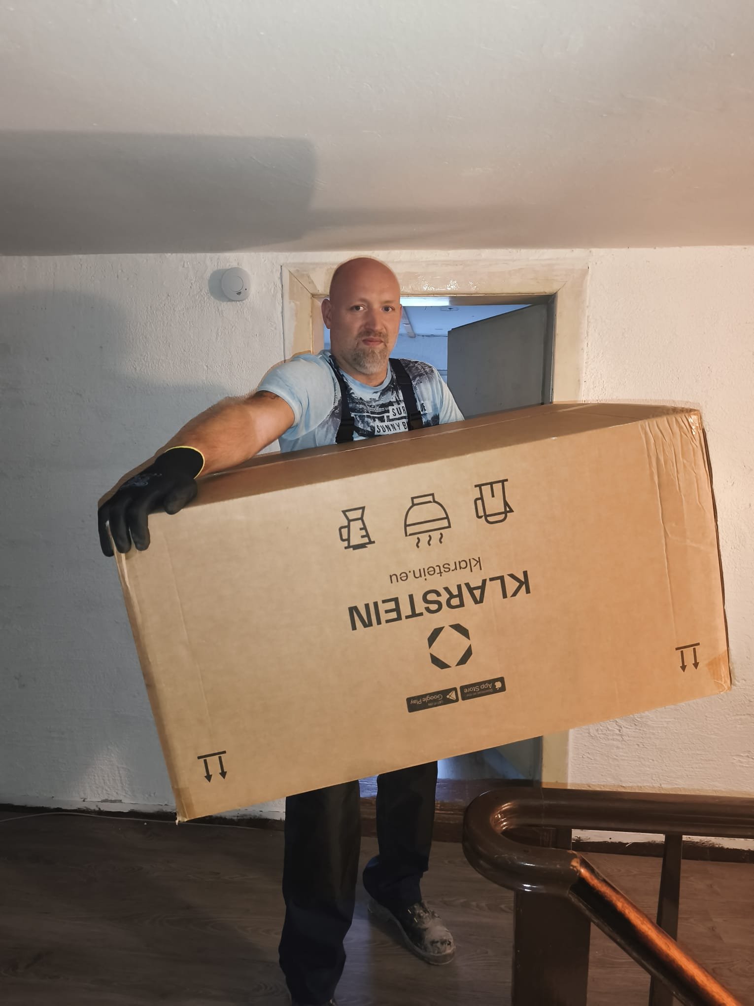 André Pusch bei der Arbeit beim Tragen eines großen Kartons